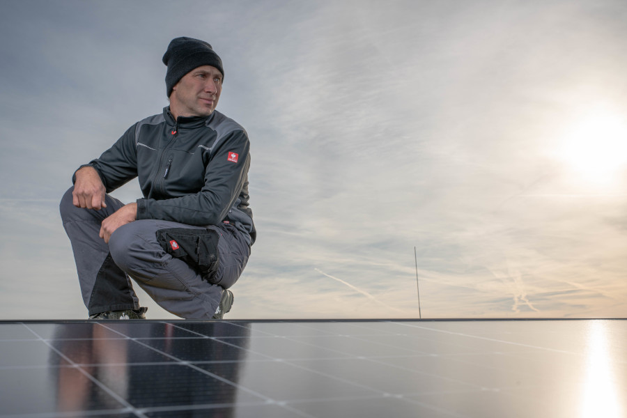 Landwirt auf einem Dach mit Solarpanele