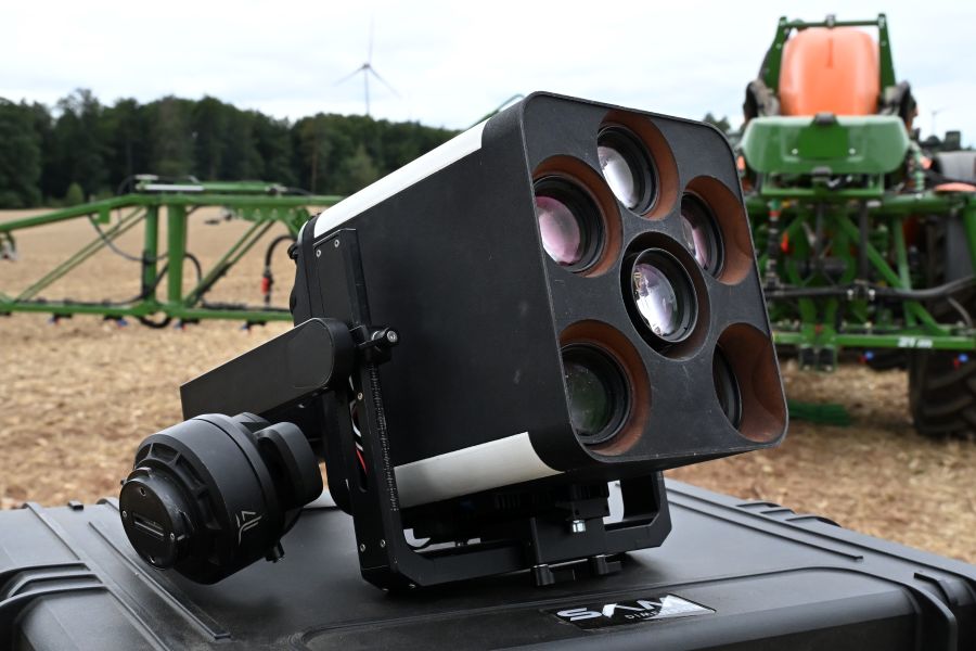 Mann steht auf Feld mit einem Tablet in der Hand
