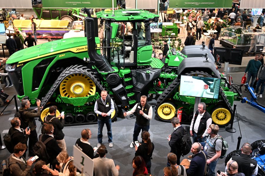 Journalisten umringen den 9RX Traktor von John Deere am Messestand.