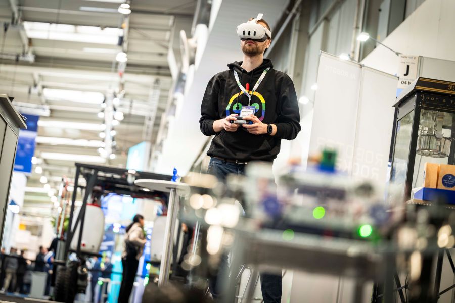 Mann mit Drohnenmaske in Messehalle